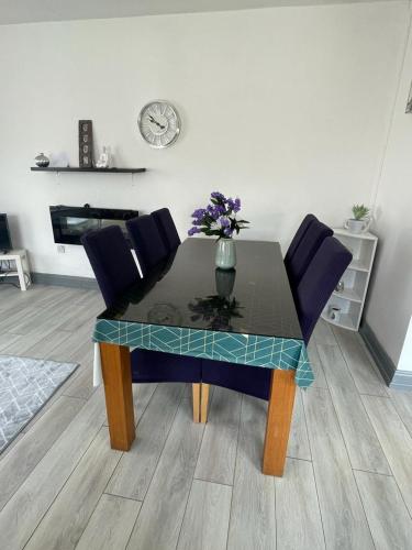 a dining room table with a vase of flowers on it at The Bungalow Castlepollard in Westmeath