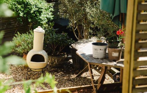 a garden with a table with plants and a large vase at Wellies & Waves in Kingsbridge