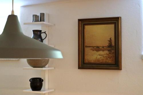 a painting on a wall with a lamp and a picture at Apartment with Terrace in the Swedish High Coast in Docksta