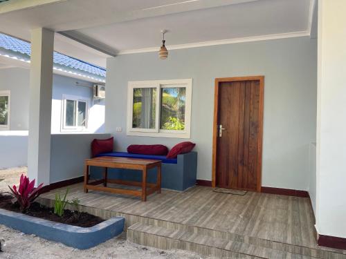 a living room with a blue couch and a wooden door at Summer Beach Paje in Paje