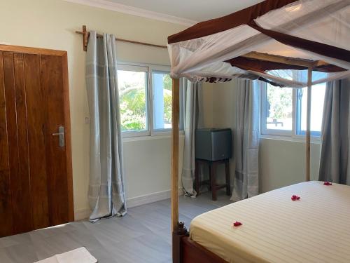 a bedroom with a bunk bed and a television at Summer Beach Paje in Paje