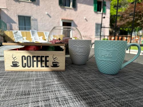 due tazze di caffè e una scatola su un tavolo di dream house a Stazzema