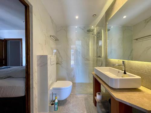 a bathroom with a sink and a toilet and a mirror at Villa Buena Vista in Palmanova