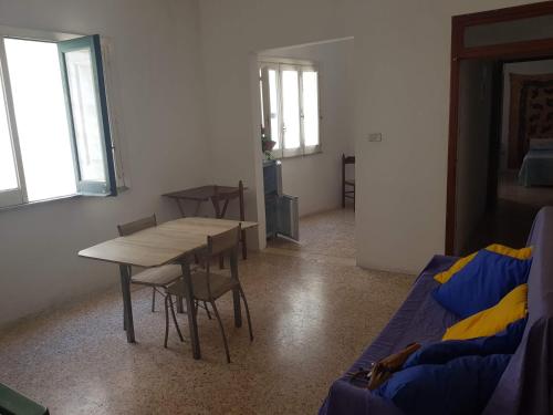 a room with a table and chairs and a couch at Zia Memè in Taviano