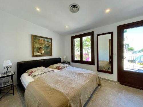a bedroom with a large bed and a large window at Villa Buena Vista in Palmanova