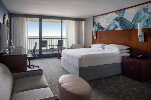 a hotel room with a bed and a living room at Hilton Beachfront Resort & Spa Hilton Head Island in Hilton Head Island