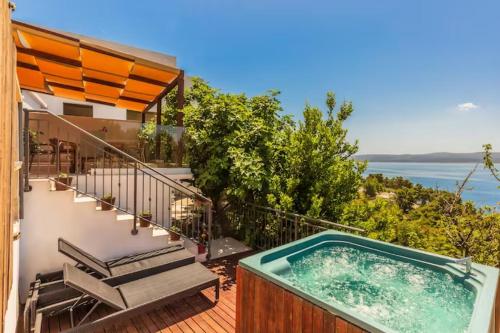 a hot tub on the balcony of a house at Blu Breeze Apartments in Lokva Rogoznica