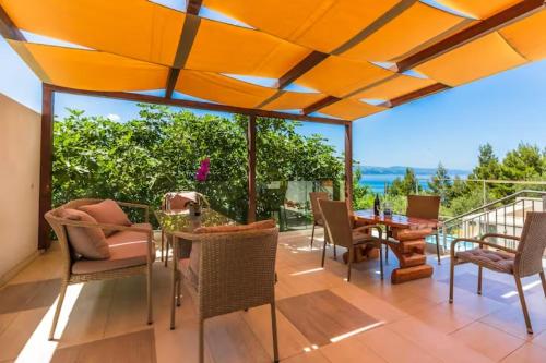 an outdoor patio with a table and chairs and a view at Blu Breeze Apartments in Lokva Rogoznica