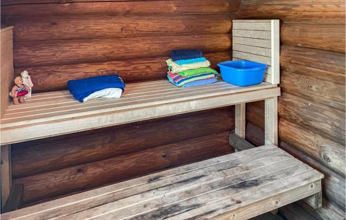 a wooden bench with towels and a blue bucket at 3 Bedroom Lovely Home In Arboga in Arboga