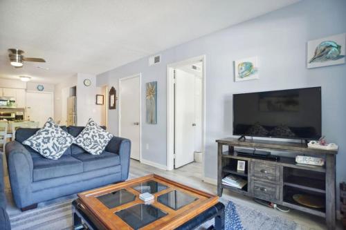 a living room with a blue couch and a flat screen tv at 5 stars Peaceful Condo - 7 min walk to the beach in Hilton Head Island