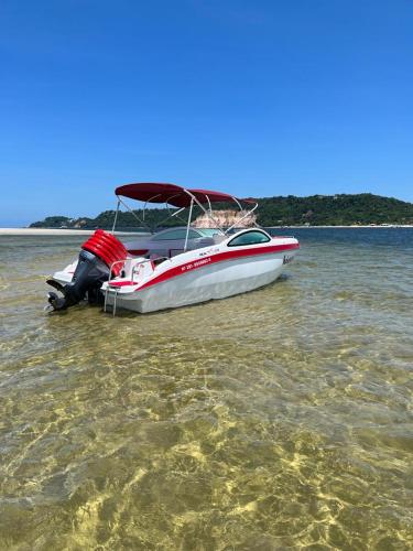 a boat sitting in the water on the beach at Pousada da praça in Morro de São Paulo