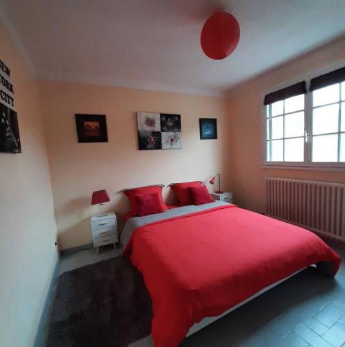 une chambre avec un grand lit rouge avec des oreillers rouges dans l'établissement Mas Provençal au Cannet des Maures, au Cannet-des-Maures