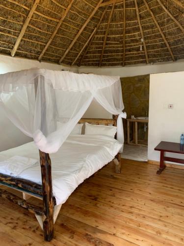 a bedroom with a bed with a mosquito net at Hillstone Safari Lodge in Kimana
