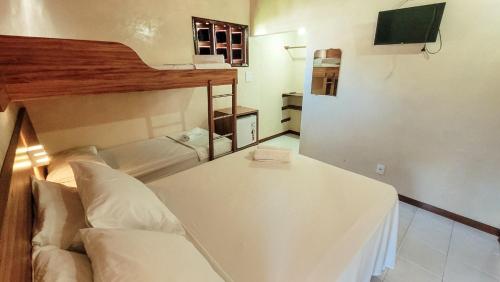 a room with a couch and a table and a tv at Pousada da praça in Morro de São Paulo