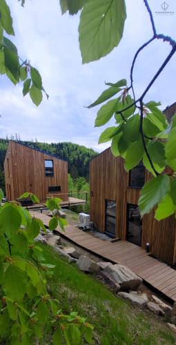 a couple of wooden buildings in a field at Widokownia Brenna in Brenna