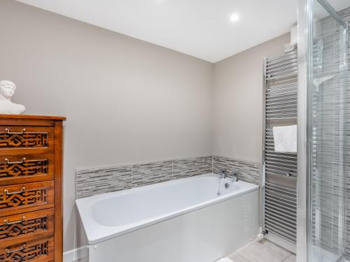 a white bathroom with a tub and a shower at Campbells Close Apartment in Edinburgh