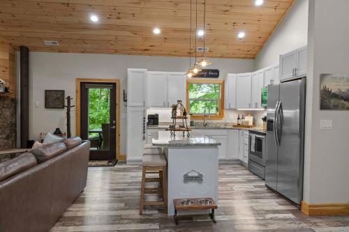 a kitchen with white cabinets and stainless steel appliances at Stunning Views, Superb Atmosphere, Modern Amenities, In the Middle of Nature in Bryson City