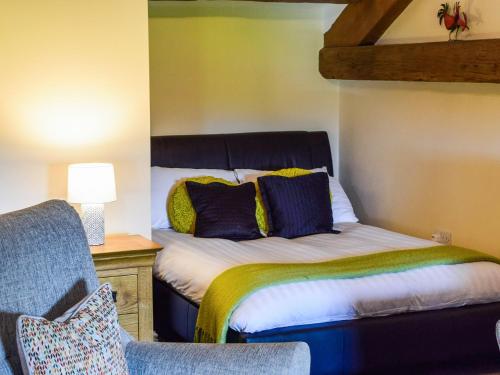 a bedroom with a bed with blue and yellow pillows at The Studio At Malt Kiln Cottage in Grizebeck