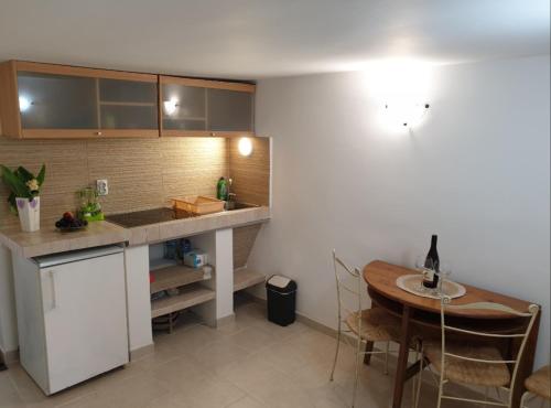 eine Küche mit einer Theke, einem Tisch und einem Esszimmer in der Unterkunft Apartman Becici in Budva