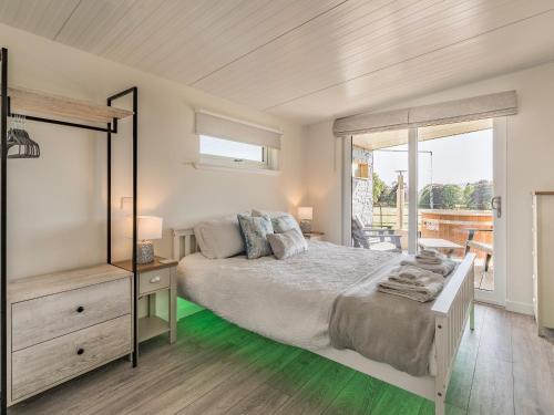 a bedroom with a large bed and a balcony at The Tranquil Orchard - Nuthatch-uk32791 in Mouswald