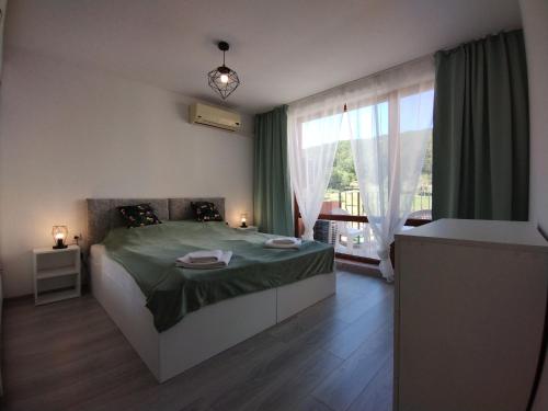 um quarto com uma cama e uma grande janela em Apartament Sea Fort Club Grand Resort Fort Noks Sveti Vlas-Bastet BS em Elenite