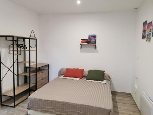 une chambre avec un lit avec deux oreillers dessus dans l'établissement Appartement Jardin et Piscine Les anges du maquis location Corse-du-Sud, à Conca