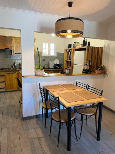 een keuken met een houten tafel en stoelen bij Ti kaz cannelle in Saint-Louis