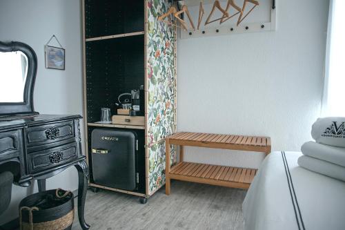 Cette chambre comprend un réfrigérateur, une table et une cuisinière. dans l'établissement Vinnus Guesthouse, à Ericeira