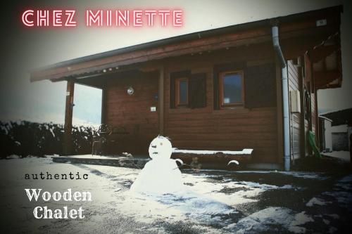 un bonhomme de neige assis devant une maison dans l'établissement Le 