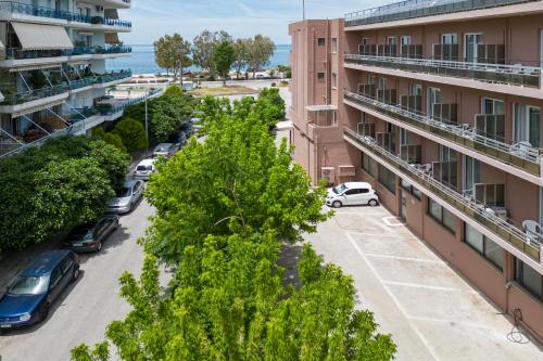 an apartment building with cars parked in a parking lot at Delfini Hotel in Patra