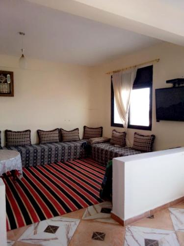 a living room with couches and a large rug at Blue meadow in Moulay Bousselham