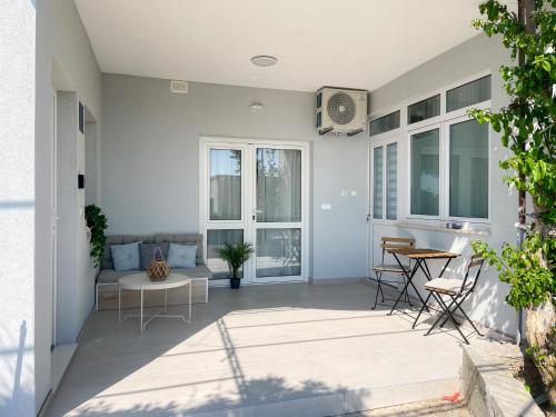 a patio with a couch and a table and chairs at Modern studio overlooking downtown in Makarska