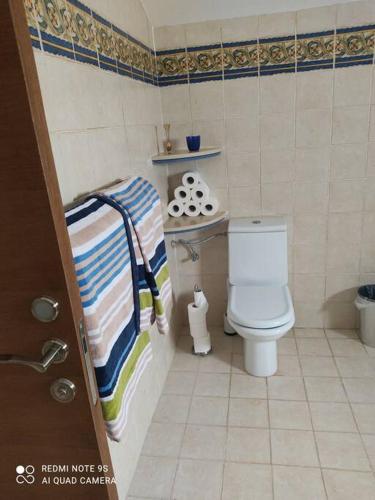 a small bathroom with a toilet and a striped towel at הבית על הגבעה in ‘Ilūṭ