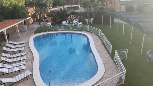 a large swimming pool with chairs next to a building at Hotel Valle Del Sol in Merlo