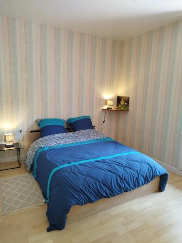 - une chambre avec un lit bleu et 2 oreillers bleus dans l'établissement AU PIED DU MOULIN, à Saint-Hilaire-de-Voust