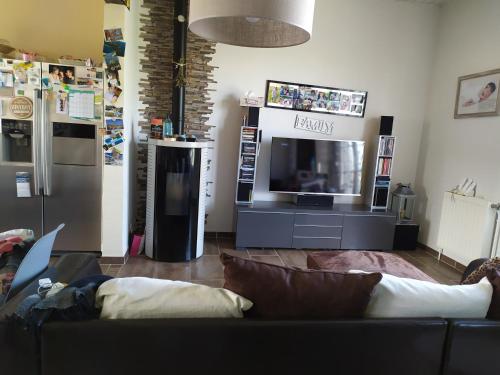 un soggiorno con divano e TV a schermo piatto di Maison avec parking privatif ad Arnage