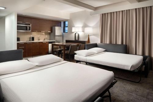 a hotel room with two beds and a kitchen at Residence Inn by Marriott New York Manhattan/ Midtown Eastside in New York