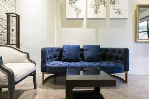 a blue couch and a chair in a living room at Inner Old Town 196 Chic Guesthouse in Bangkok