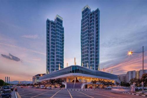 two tall buildings in a city with a parking lot at Top Sea View - Maritime Suite 只有海景房 in Jelutong
