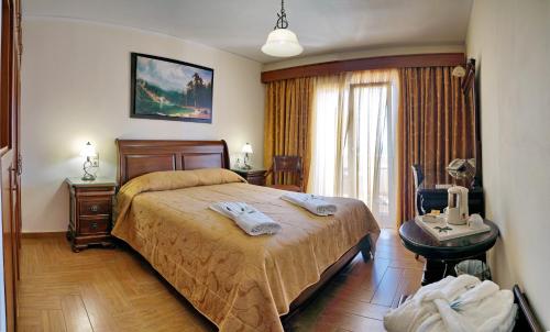 a bedroom with a bed and a table and a chair at HOTEL VICKY II in Plomari