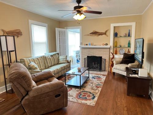 a living room with a couch and a fireplace at Calypso Pensacola in East Hill Neighborhood ! in Pensacola