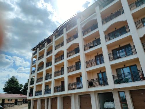 a large white building with a car parked in it at Apartment Sunny in Casa Del Mare in Varna City