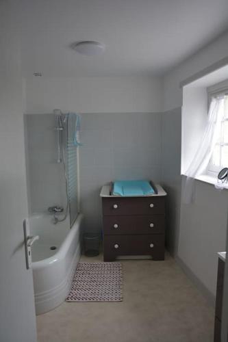 une salle de bain avec une baignoire, une douche et un lavabo dans l'établissement maison de village barfleur, à Barfleur