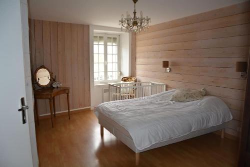une chambre avec un lit et un mur en bois dans l'établissement maison de village barfleur, à Barfleur