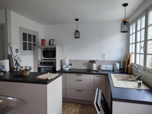 une cuisine avec un évier et un plan de travail dans l'établissement maison de village barfleur, à Barfleur