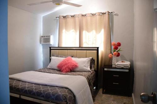 a bedroom with a bed with a pink fluffy pillow at Apartamento entero en Samaná Los tios in Santa Bárbara de Samaná