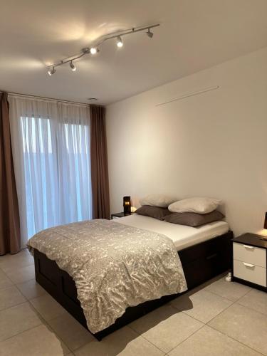 a bedroom with a bed and a large window at Canal View One Bedroom Flat in Brussels