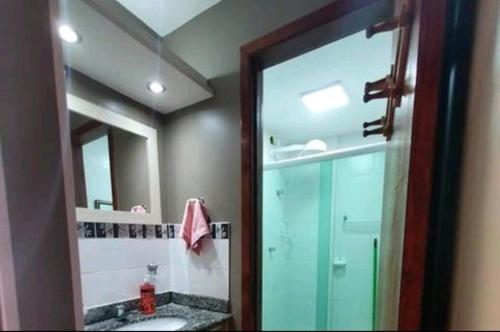 y baño con ducha de cristal y espejo. en Villa da Praia Resort - Orla Praia Grande, en Arraial do Cabo