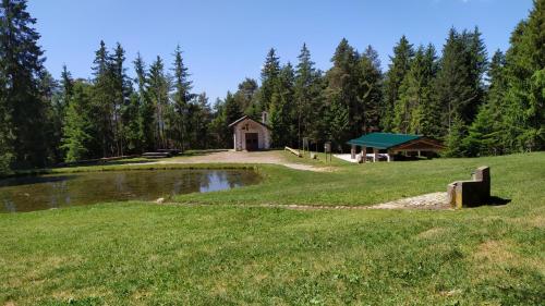 a large field with a building in the middle of a lake at Cinque Abeti Agrialloggio Mountain Lake Iseo Hospitality in Bossico