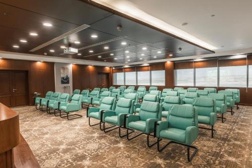 a conference room with green chairs and a podium at Gewan White Beach Resort-New Alamein in Marsa Matruh